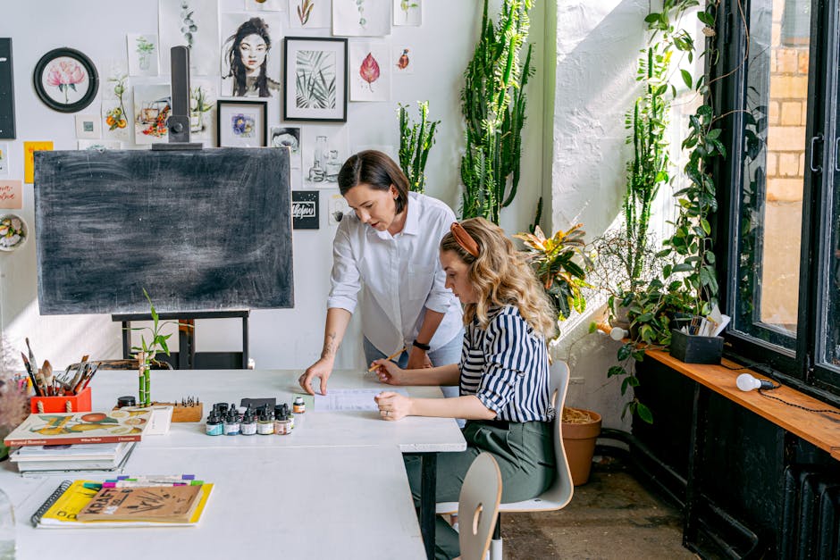 Instructor guiding a student in a vibrant art studio filled with plants and artworks.